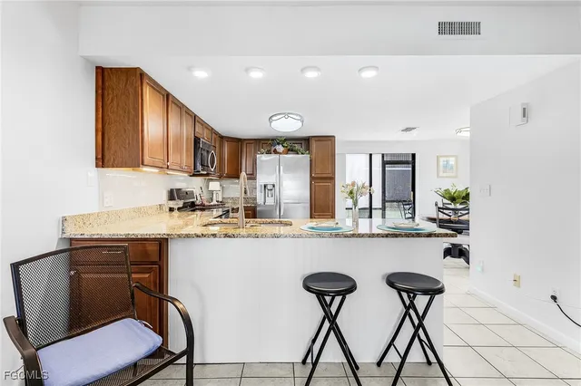 a kitchen with a table chairs refrigerator and cabinets