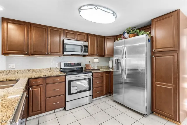 a metallic refrigerator freezer sitting inside of a kitchen