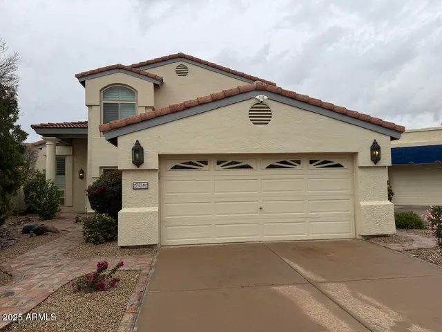 a view of a white house with a yard and garage