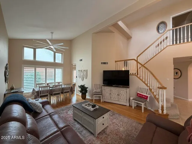 a living room with furniture a flat screen tv and a large window