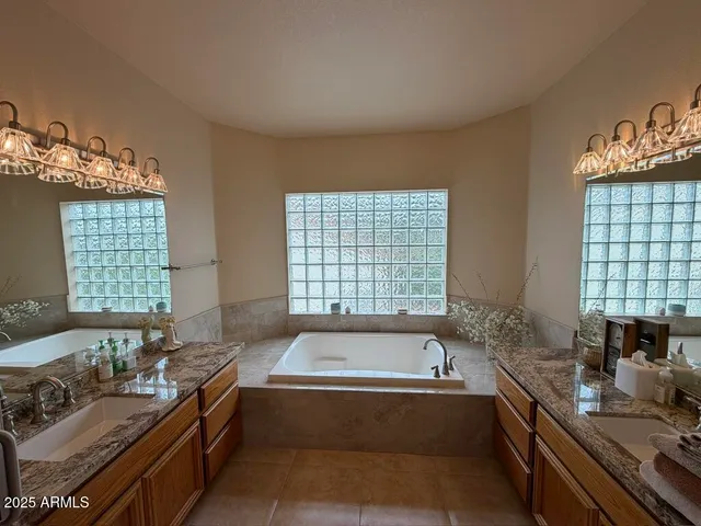 a bathroom with a tub sink and windows