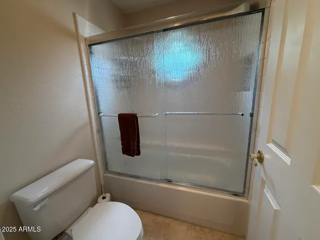 an empty room with windows and a ceiling fan