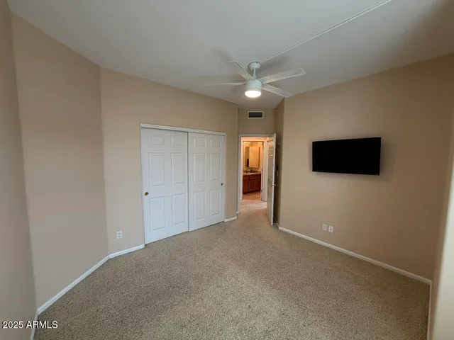 a bedroom with a bed and a flat tv screen on a dresser