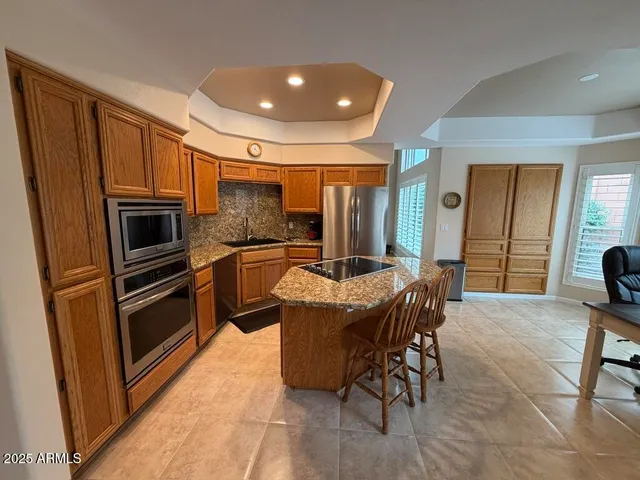 a kitchen with sink refrigerator dining table and chairs