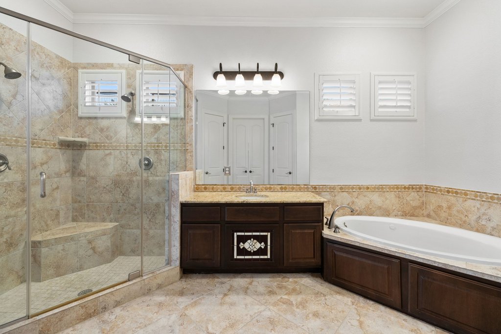 109 Largo Cove Austin, TX 78734 - Photo 20 of 40 Indulge in a tranquil bathing experience within this generously proportioned bathroom, featuring a deep soaking tub and a spacious walk-in shower.