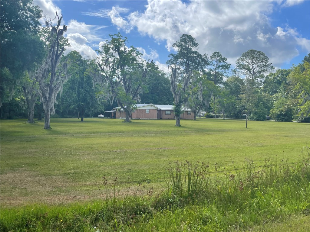 45013 Bismark Road Callahan, FL 32011 - Photo 15 of 26 a view of a pool with lawn chairs and a large tree