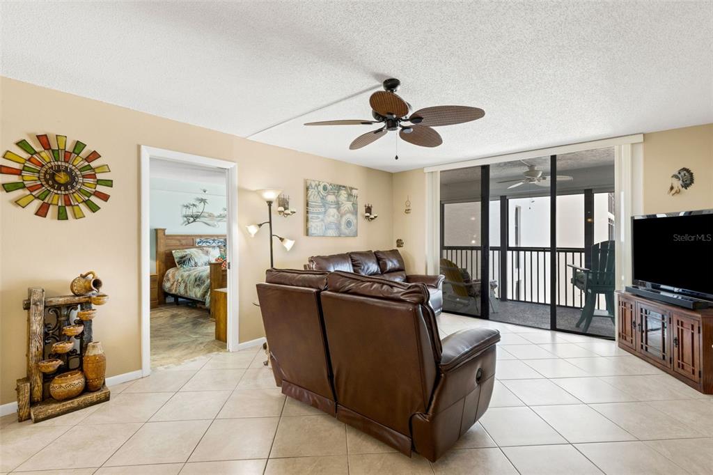 14900 Gulf Boulevard, Unit 410 Madeira Beach, FL 33708 - Photo 26 of 76 a living room with furniture a flat screen tv and a refrigerator