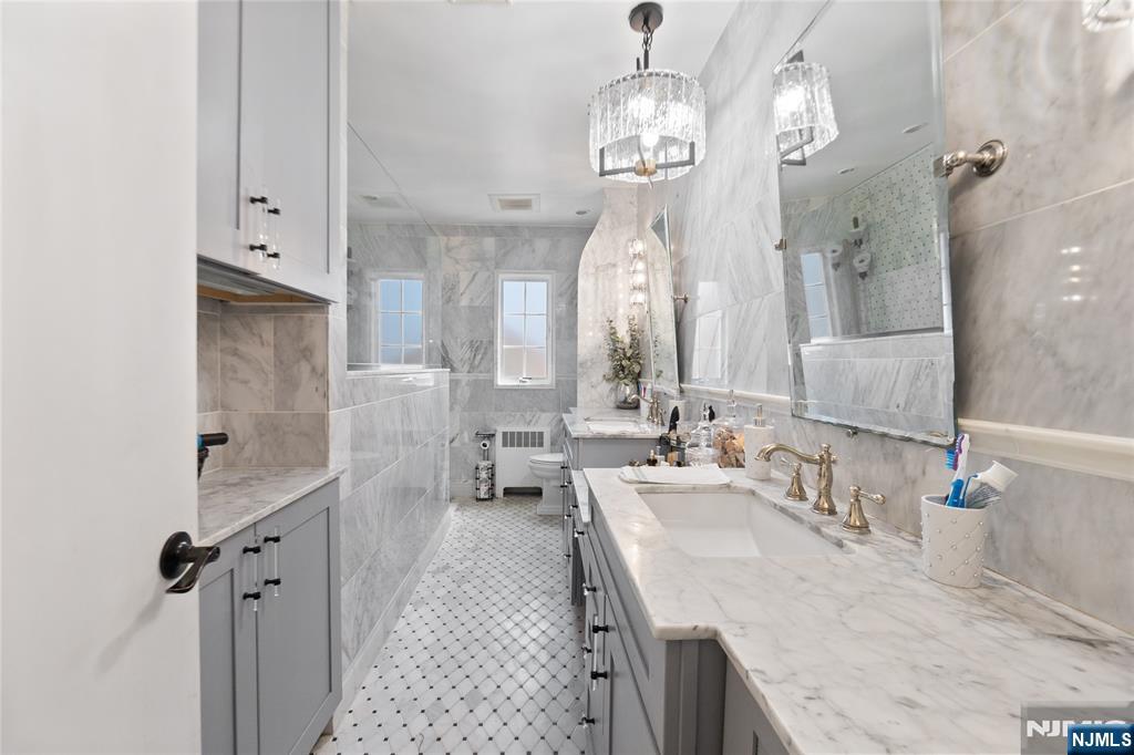 120 South Prospect Avenue Hackensack, NJ 07601 - Photo 12 of 24 a spacious bathroom with double vanity and a mirror