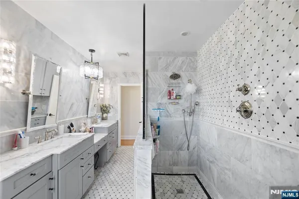 a spacious bathroom with a double vanity sink mirror and shower