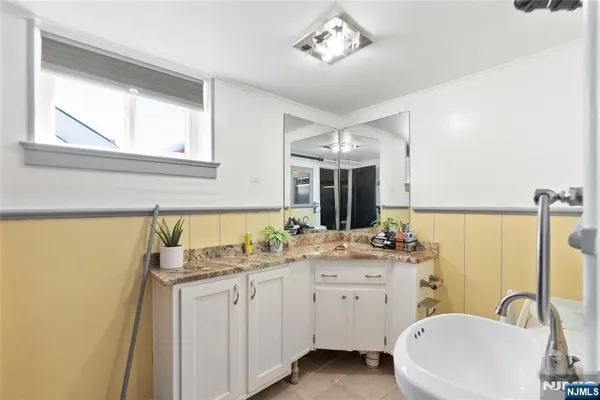a spacious bathroom with a double vanity sink a mirror a and a window