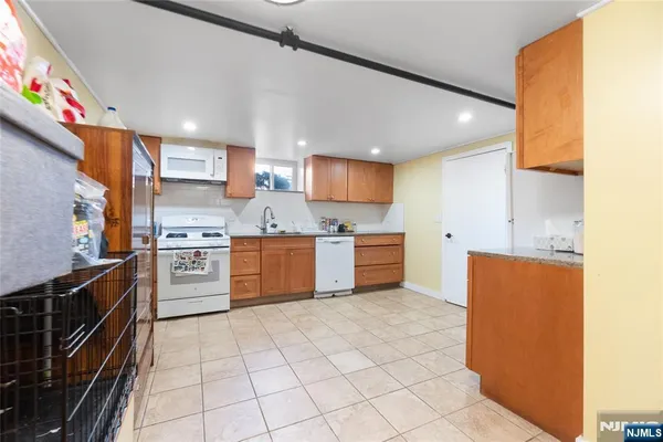 a kitchen with granite countertop a sink counter top space cabinets and stainless steel appliances