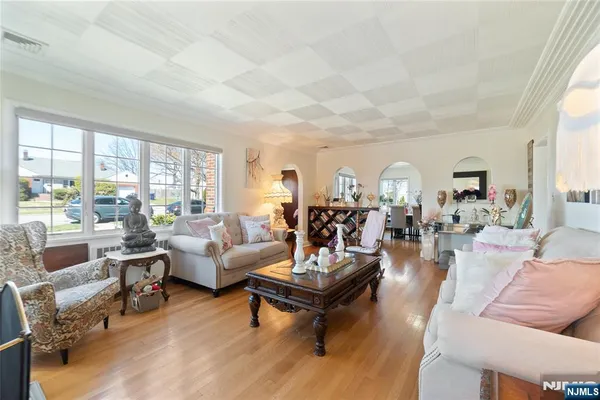 a living room with furniture large windows and wooden floor