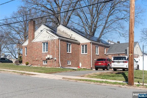 a front view of a house with a garden and parking space
