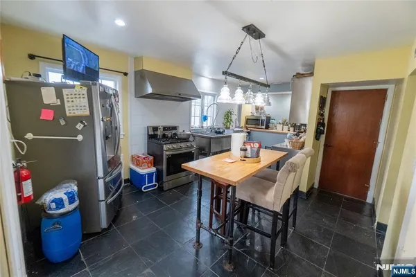 a room with stainless steel appliances kitchen island a table and chairs