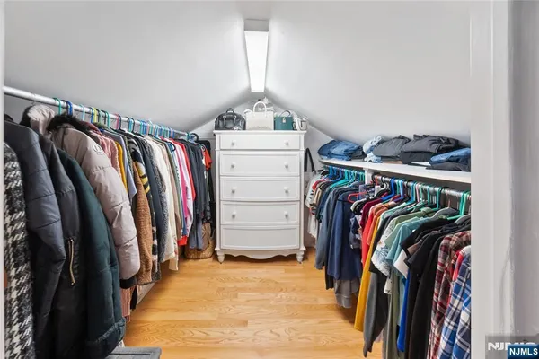 a view of walk in closet with clothes and shoes