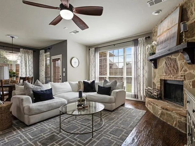 a living room with furniture a fireplace and a large window