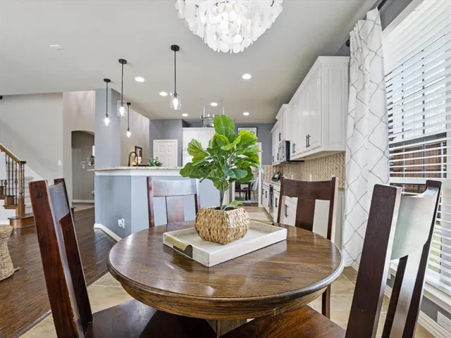a view of a dining room with furniture a chandelier and wooden floor