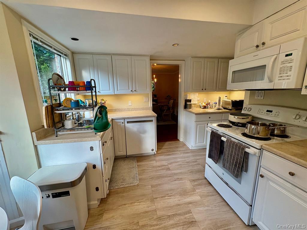 5 Rockcrest Road Manhasset, NY 11030 - Photo 8 of 16 Kitchen featuring white appliances, white cabinets, light countertops, and recessed lighting