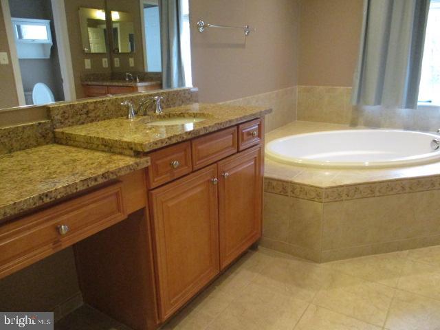 3547 Goddard Way Alexandria, VA 22304 - Photo 25 of 38 a bathroom with a granite countertop sink a mirror and a bathtub