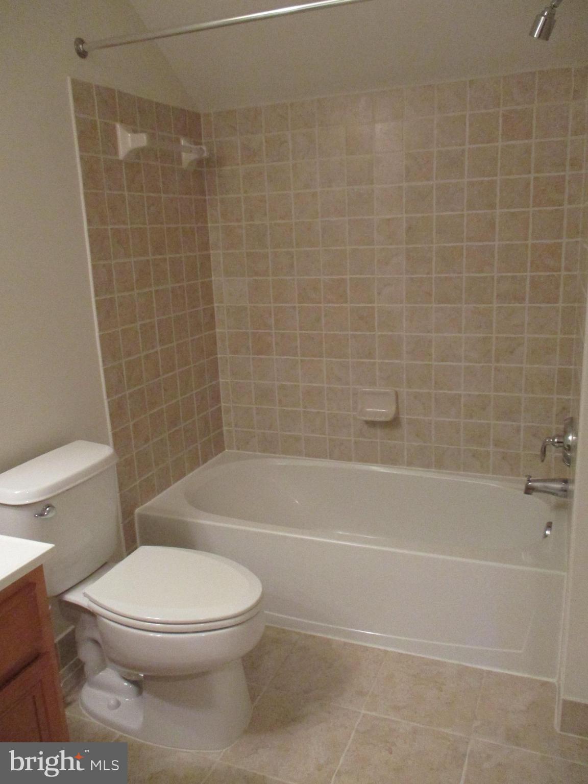 3547 Goddard Way Alexandria, VA 22304 - Photo 34 of 38 a white toilet and tub sitting next to a bathroom sink