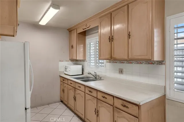 a kitchen with stainless steel appliances granite countertop a sink and dishwasher with white cabinets