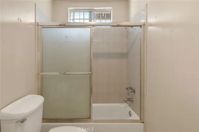 an empty room with a window and a ceiling fan