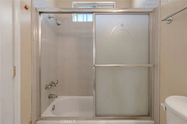 an empty room with wooden floor chandelier fan and windows