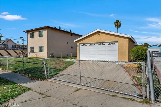 a view of a house with a small yard and a large tree