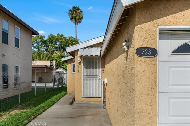 a view of a kitchen with a sink a kitchen island white cabinetry and refrigerator