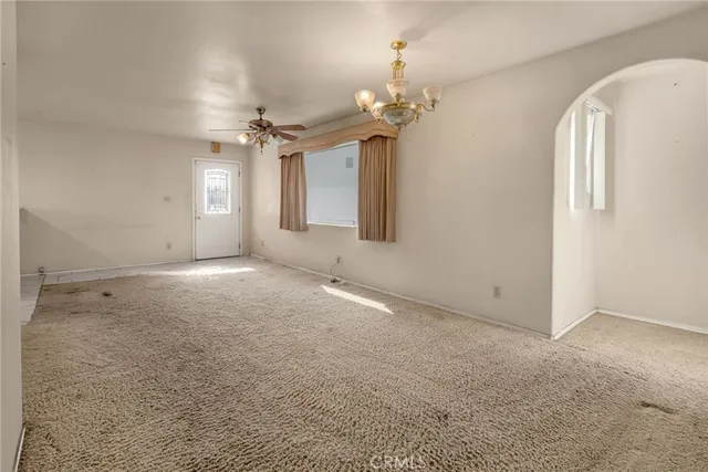en empty room with windows and ceiling fan