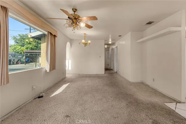en empty room with windows and ceiling fan