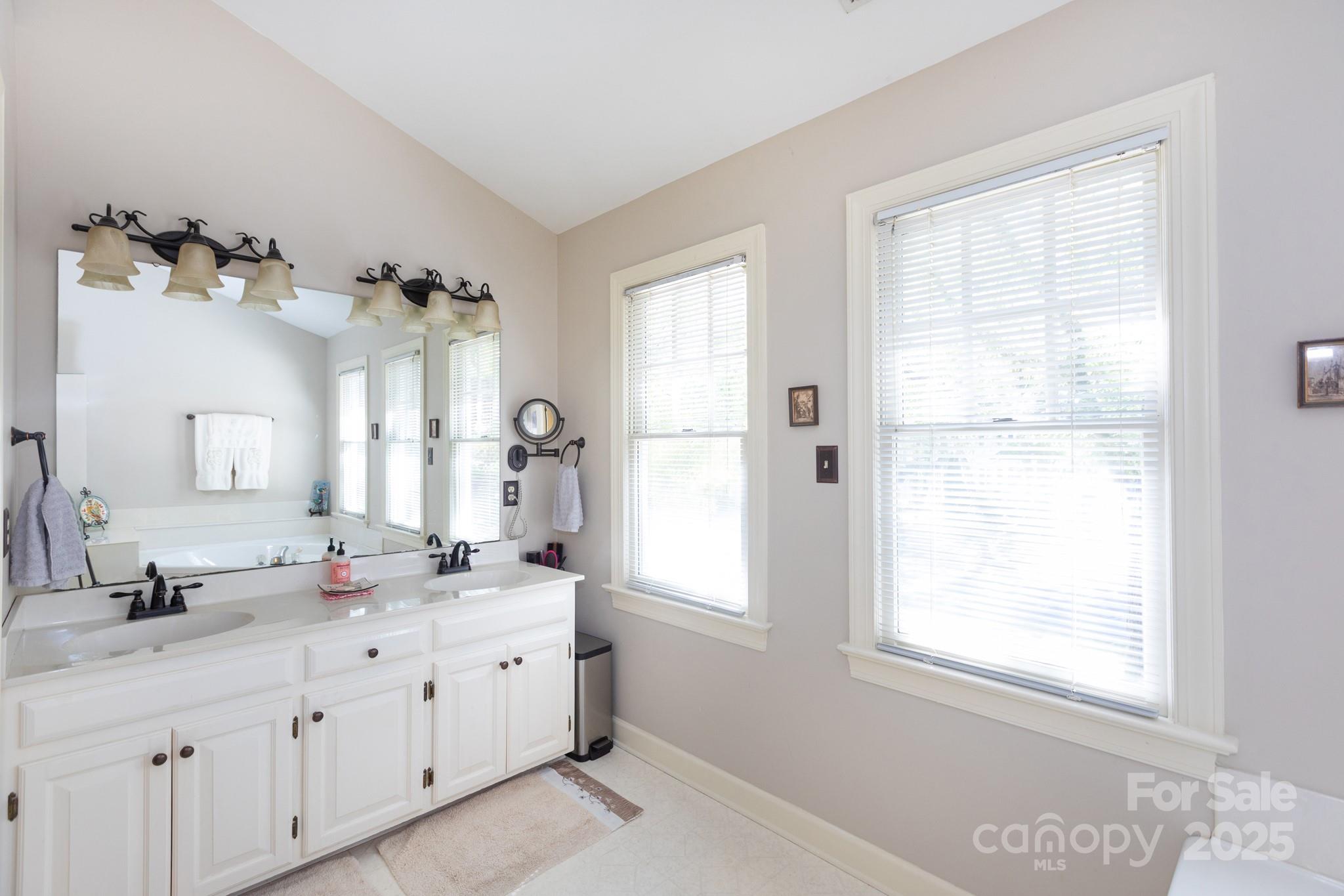 9112 Laurel Ridge Trail Charlotte, NC 28269 - Photo 16 of 38 a bathroom with double vanity sinks a mirror and a window