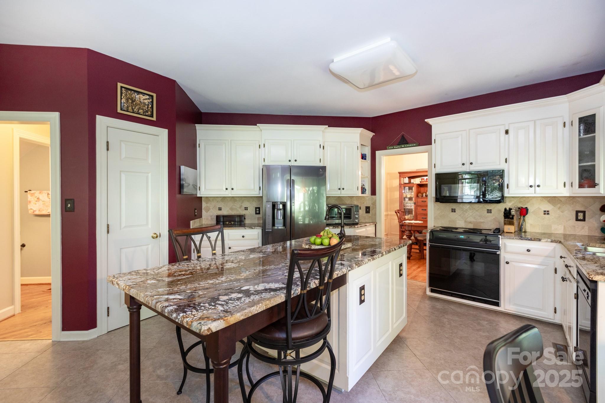 9112 Laurel Ridge Trail Charlotte, NC 28269 - Photo 9 of 38 a kitchen with stainless steel appliances granite countertop a stove top oven a sink dishwasher and a refrigerator with wooden floor