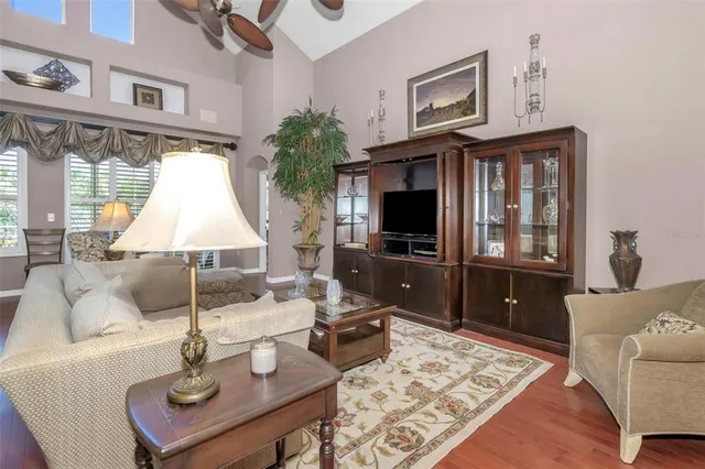 a living room with furniture a flat screen tv and a table