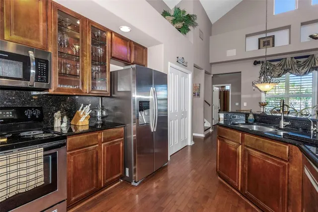 a kitchen with stainless steel appliances granite countertop a refrigerator and a stove top oven