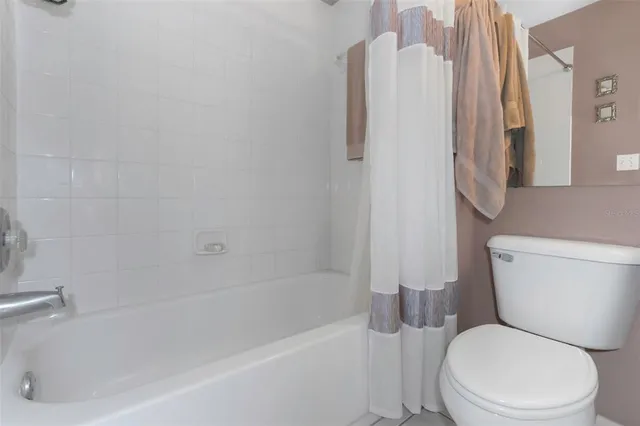a white toilet sitting next to a bath tub