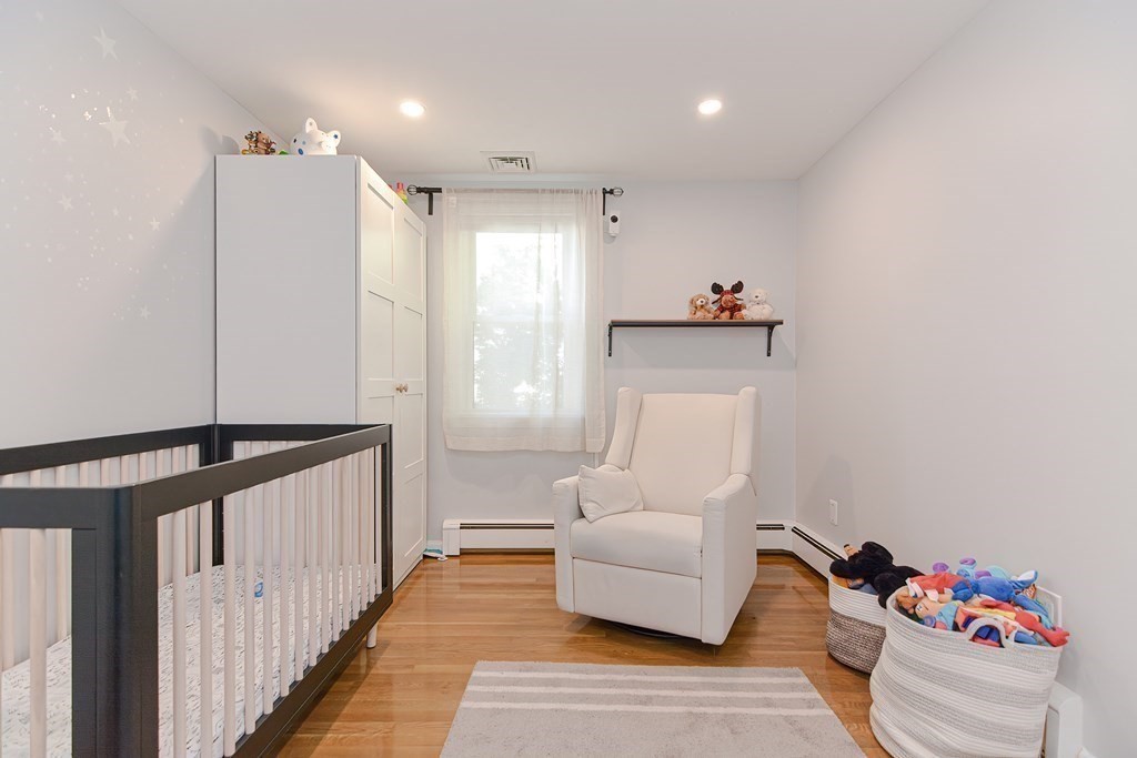 14 Oakcrest Drive Framingham, MA 01701 - Photo 22 of 42 a hallway with a couch and a dresser with wooden floor