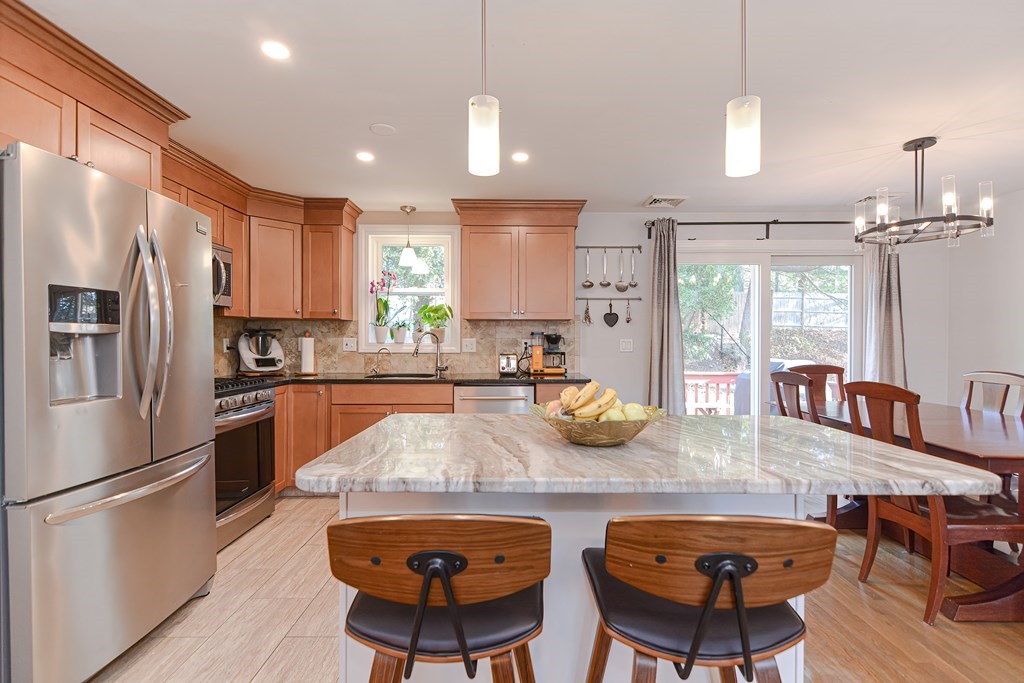 14 Oakcrest Drive Framingham, MA 01701 - Photo 3 of 42 a kitchen with stainless steel appliances granite countertop a stove a refrigerator a sink a dining table and chairs with wooden floor