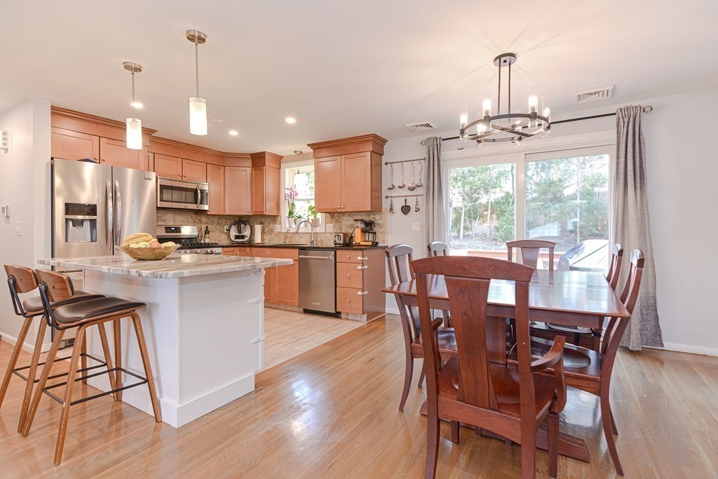 14 Oakcrest Drive Framingham, MA 01701 - Photo 8 of 42 a kitchen with stainless steel appliances a dining table chairs and granite counter tops