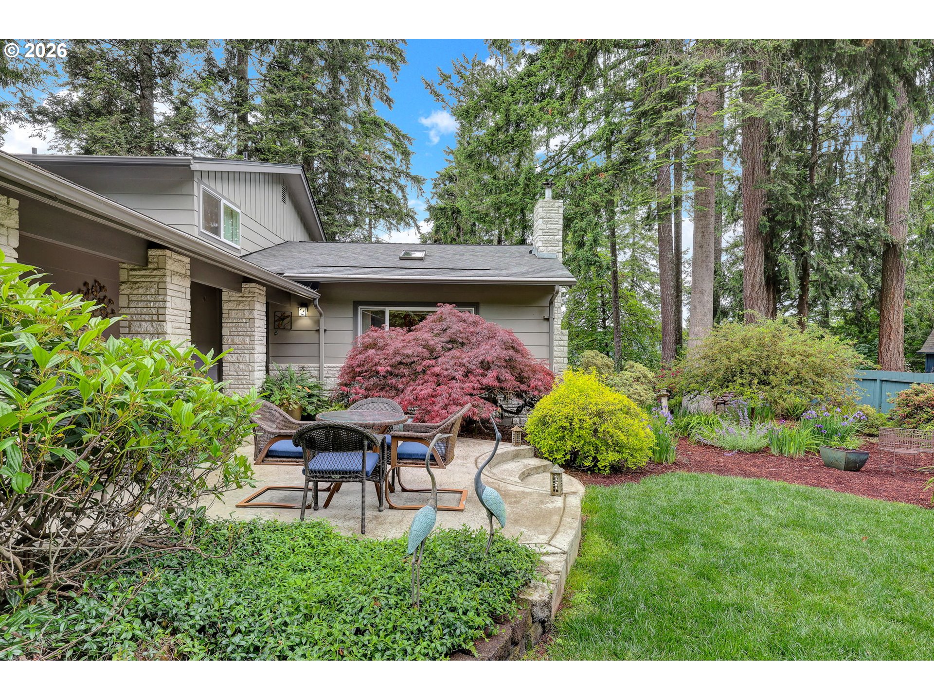 88108 Tiki Lane Springfield, OR 97478 - Photo 6 of 48 a garden with a bench in front of the house