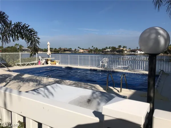 a view of a roof deck with couches and wooden fence