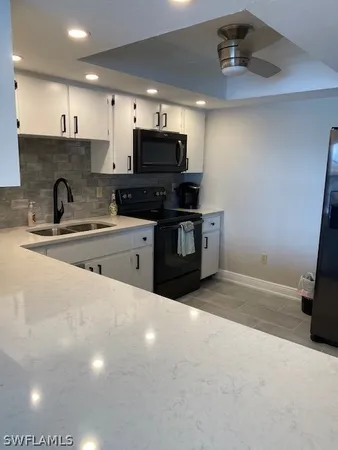a kitchen with stainless steel appliances granite countertop a sink and a stove top oven with wooden floor