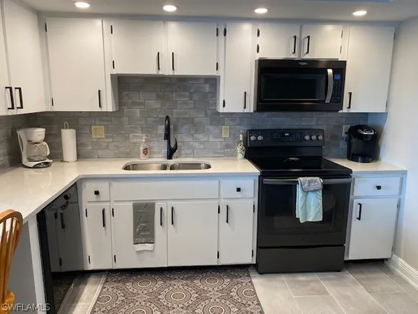a kitchen with a sink stove and microwave