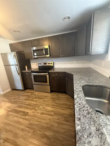 a large kitchen with stainless steel appliances granite countertop a sink and a stove