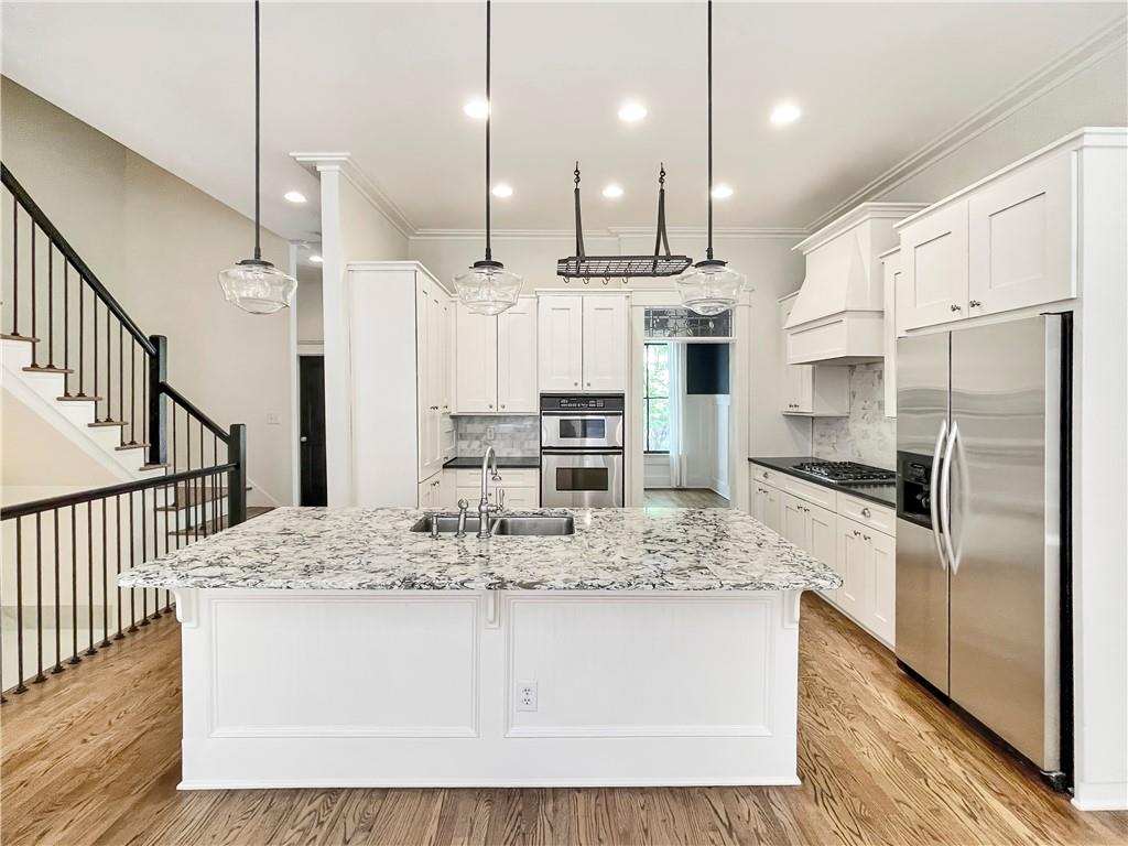 1867 Gordon Manor Northeast Atlanta, GA 30307 - Photo 13 of 34 a kitchen with stainless steel appliances kitchen island granite countertop a refrigerator a oven a sink and white cabinets with wooden floor