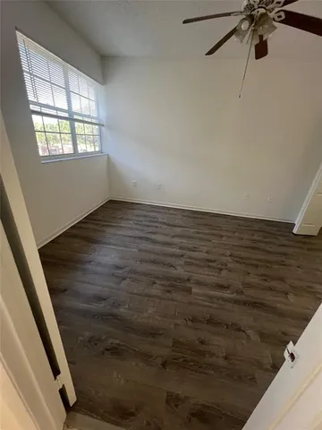 a view of a room with window and a ceiling fan