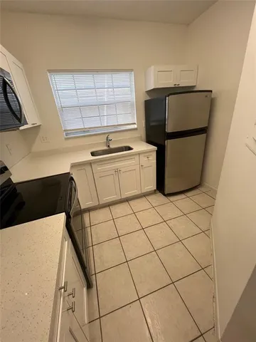 a kitchen with stainless steel appliances a refrigerator sink and cabinets