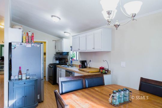 1140 North Calvert Boulevard Ridgecrest, CA 93555 - Photo 9 of 27 a kitchen with stainless steel appliances granite countertop a sink dishwasher stove and refrigerator with wooden floor
