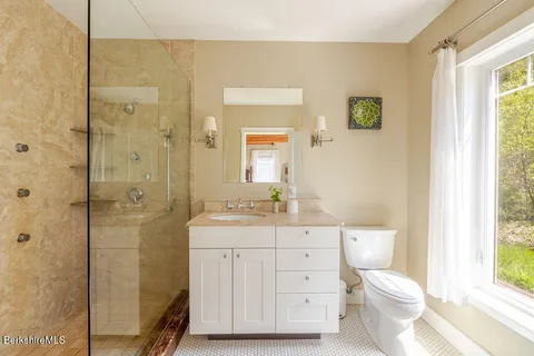 a bathroom with a sink a toilet and shower