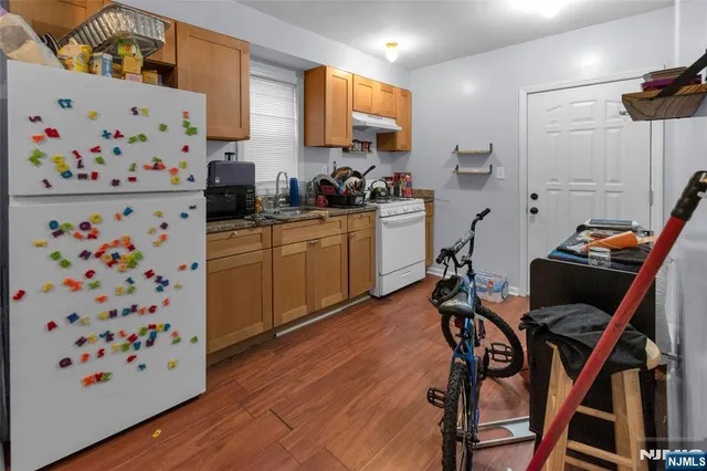 a kitchen with stainless steel appliances a dining table chairs and a refrigerator